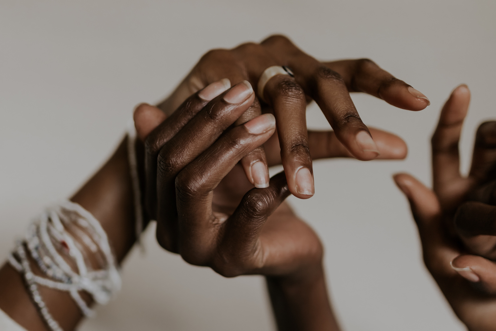 Black women holding and touching hands
